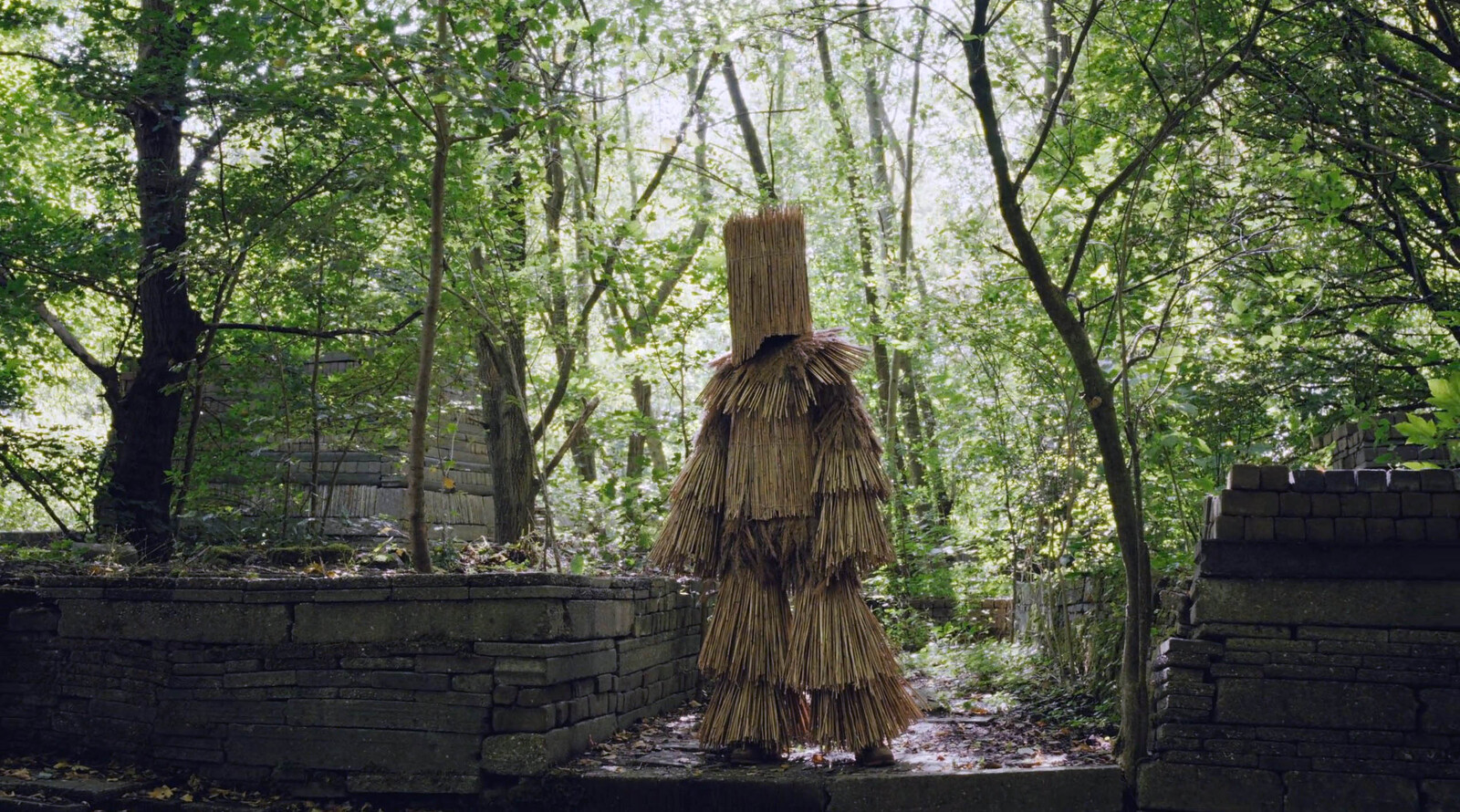 Een rieten man wandelt door de ecokathedraal in de videoclip 'Rein' van Jasper de Bruin met zangeres Immen  (still uit de video)